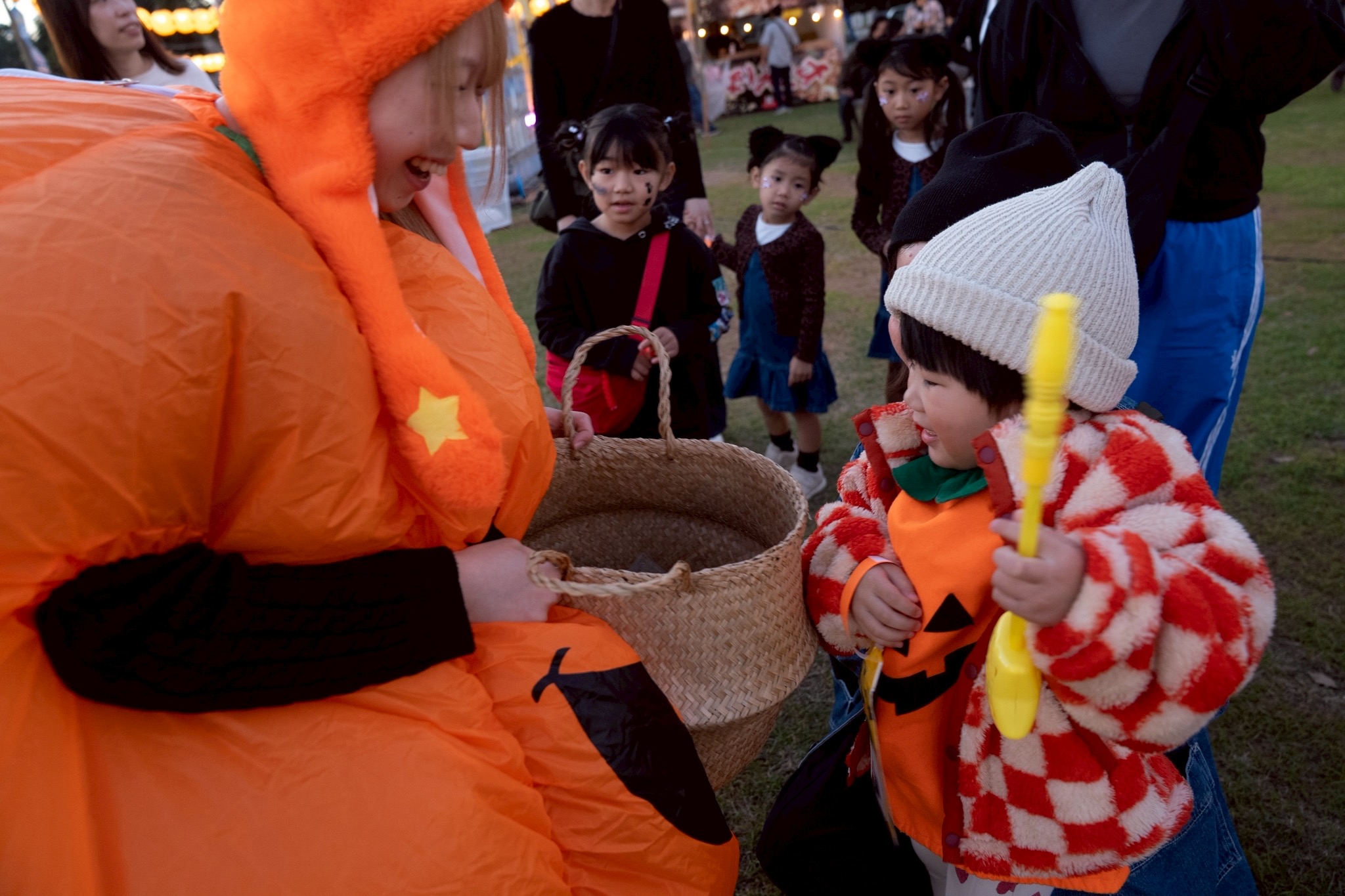 2025年、かぼちゃスタッフからお菓子を受け取る子ども